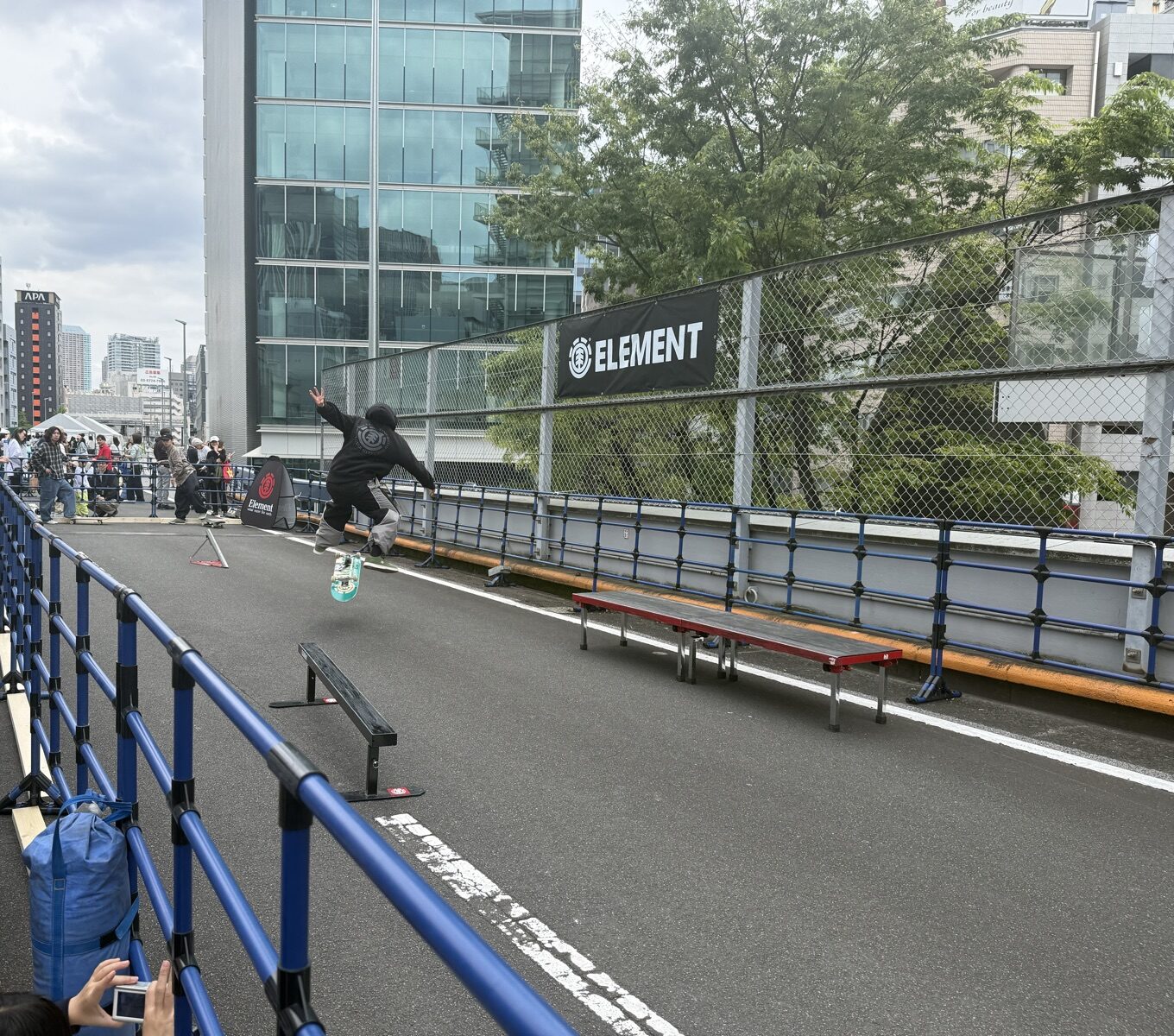 ELEMENT看板の前で熟練者がスケートボードのジャンプ技を披露