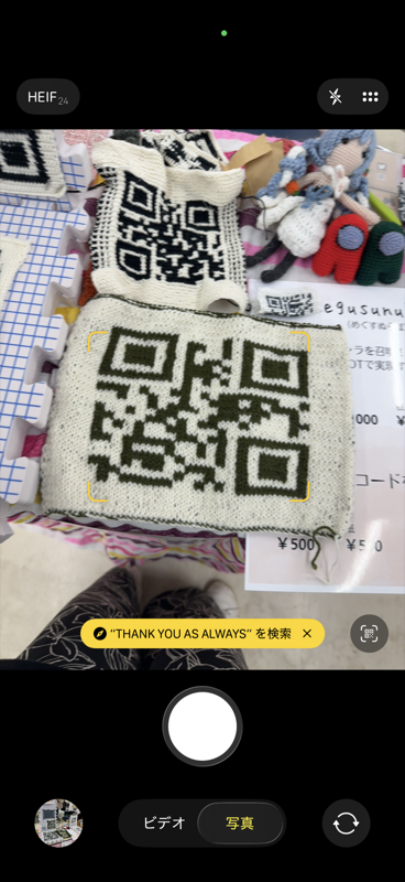 棒針編みのQRコードをスマートフォンで読み取っている様子——「THANK YOU AS ALWAYS」が検出されている